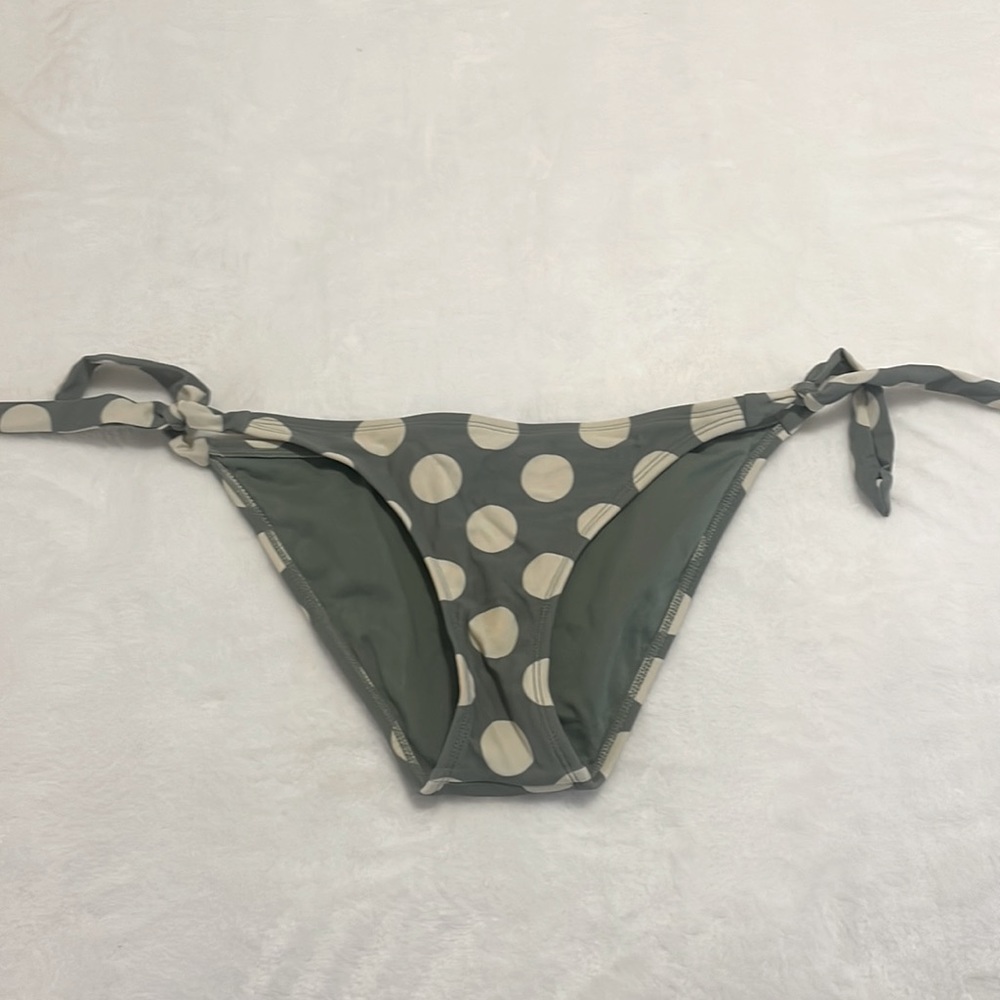 Never worn swim suit. Green and beige polka dot adjustable tie on the sides.